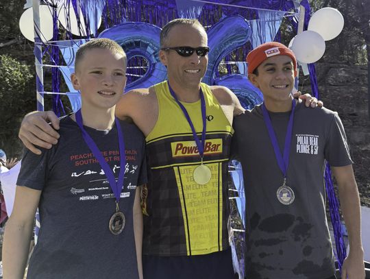 Submitted Photo. Winners of the 2026 Polar Bear Plunge 5K race pose after their cool down plunge in Cypress Creek. Taking first place was James Bales, center. The second place runner was Nathan Cisneros, right, and in third place was Noah Bales, left.