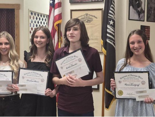 Submitted Photo VFW Post 6441 Commander Brady Love awarded Audio and essay winners, left to right, Quinn Jennings, Carolina Manes, Austin Sanchez and Rosie Zinkgraf in the Voice of Democracy and Patriot Pen contests. Not pictured is Tinley Williams.