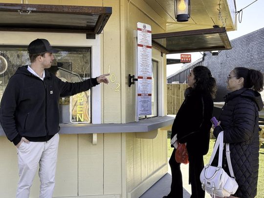 Photo by Teresa Kendrick Trevor Airola, the owner of Rocky Mountain Crepes in Wimberley, answers questions from customers about his menu.
