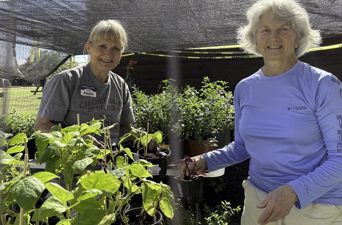 Master Gardeners Kathleen Crabill and Connie Wierman stage plants near the Jacob’s Well Greenhouse and Demonstration Garden. Photo by Teresa Kendrick