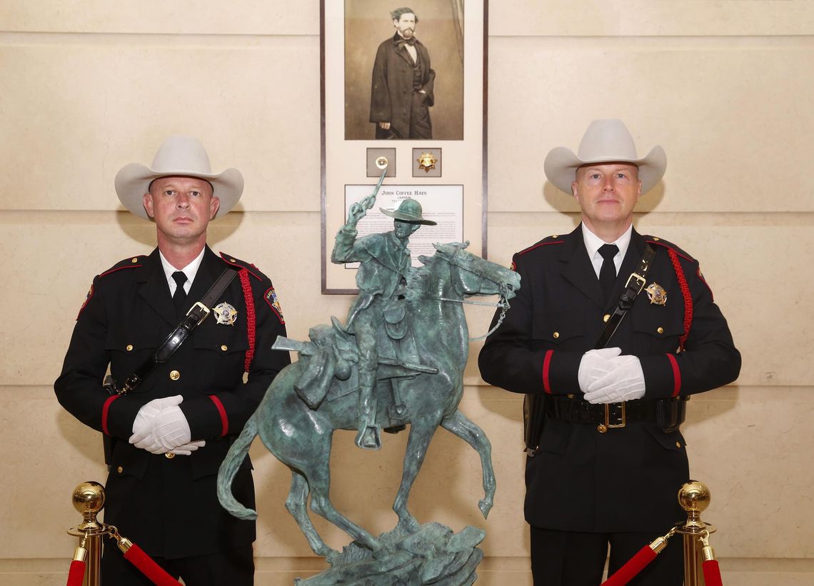Jack Hays Collection debuts at Government Center Daily Record photo by John Clark Hays County Sheriff’s Office Honor Guard members left: Mark Opiela and right: Scott Zediker, with the statue and portrait presented in the Jack Hays Collection.