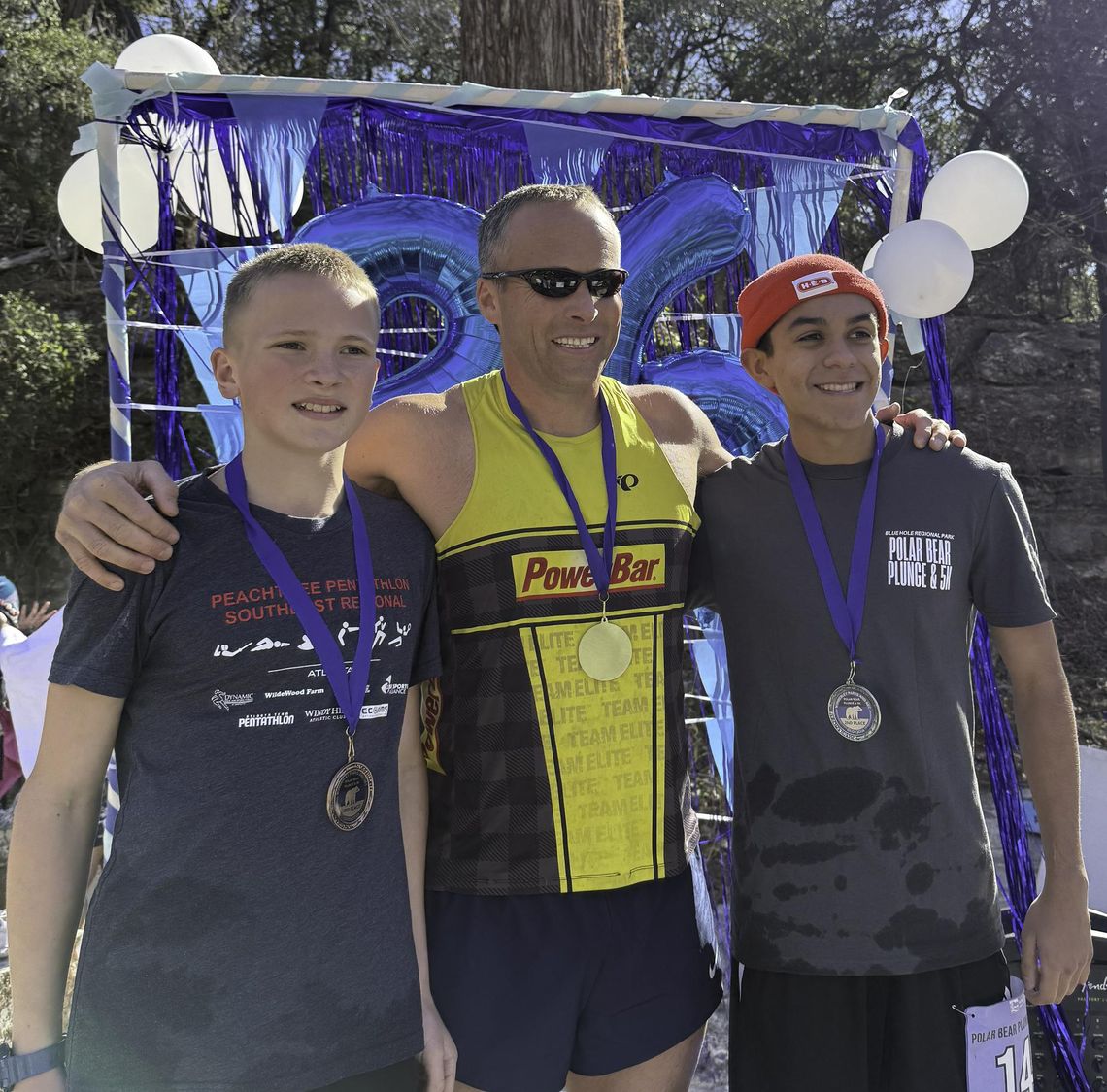 Submitted Photo. Winners of the 2026 Polar Bear Plunge 5K race pose after their cool down plunge in Cypress Creek. Taking first place was James Bales, center. The second place runner was Nathan Cisneros, right, and in third place was Noah Bales, left.