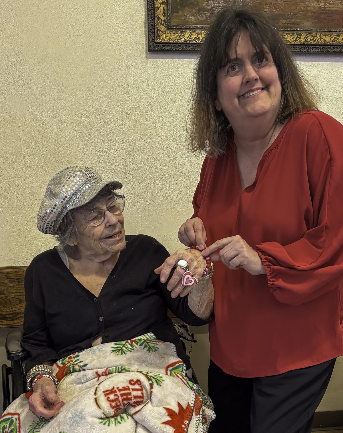 Kathleen Morgan, right, who sponsored the event, is shown putting a finished...