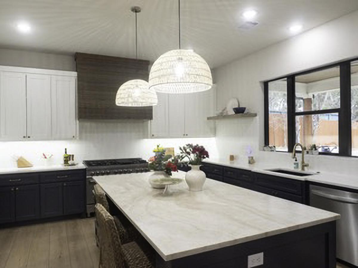 A Taj Mahal stone island anchors the kitchen in the “Hilltop Modern Retreat.”...